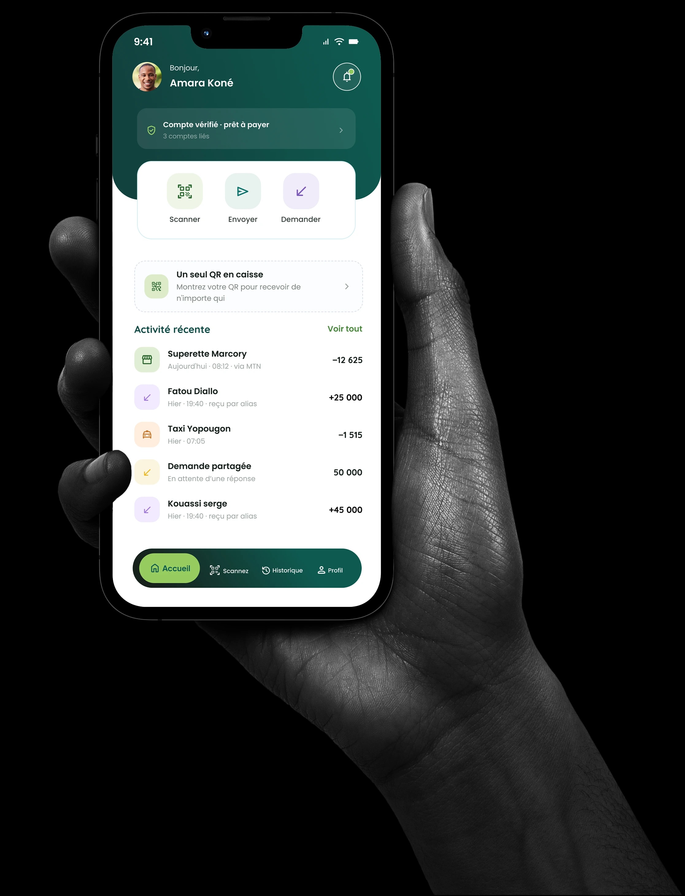 Une main tient un téléphone affichant l'accueil de l'application OOQAMI